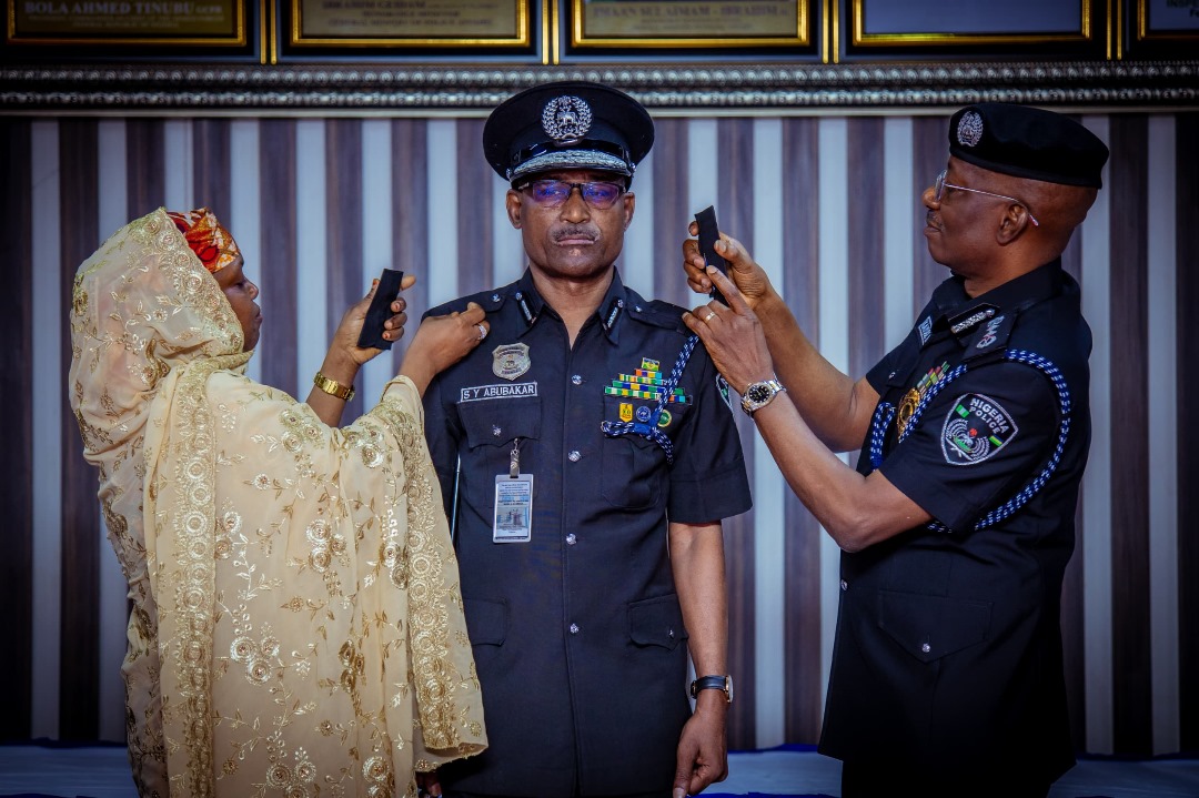 R-L: Inspector-General of Police, Nigeria Police Force, IGP Kayode Egbetokun decorating the newly promoted Deputy Inspector General of Police, DIG Yahaya Sahabo Abubakar supported by the DIG Abubakar's wife.