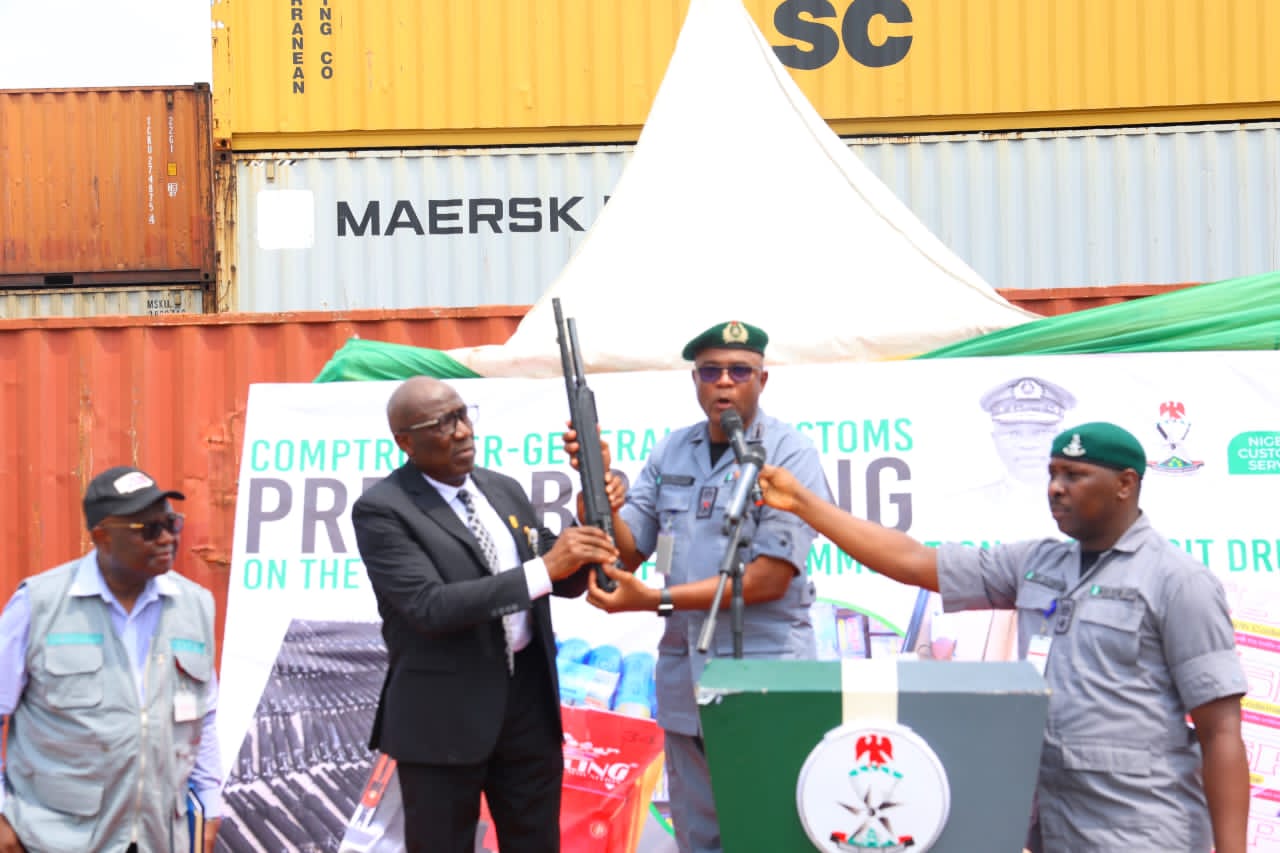 The Custom officer handing-over the impounded arms and ammunition to DIG Johnson Kokumo rtd